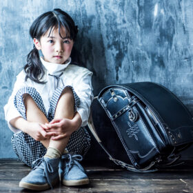 7歳の女の子がスタジオイリュームでランドセルと一緒に撮影しているお洒落な入学写真。